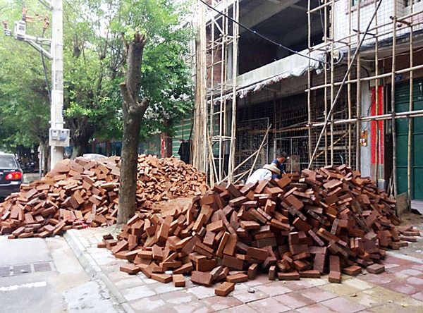 建設(shè)路建筑材料亂堆放，人行道變“攔路虎”